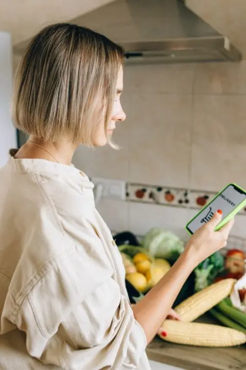 Woman in the kitchen looking at her phone